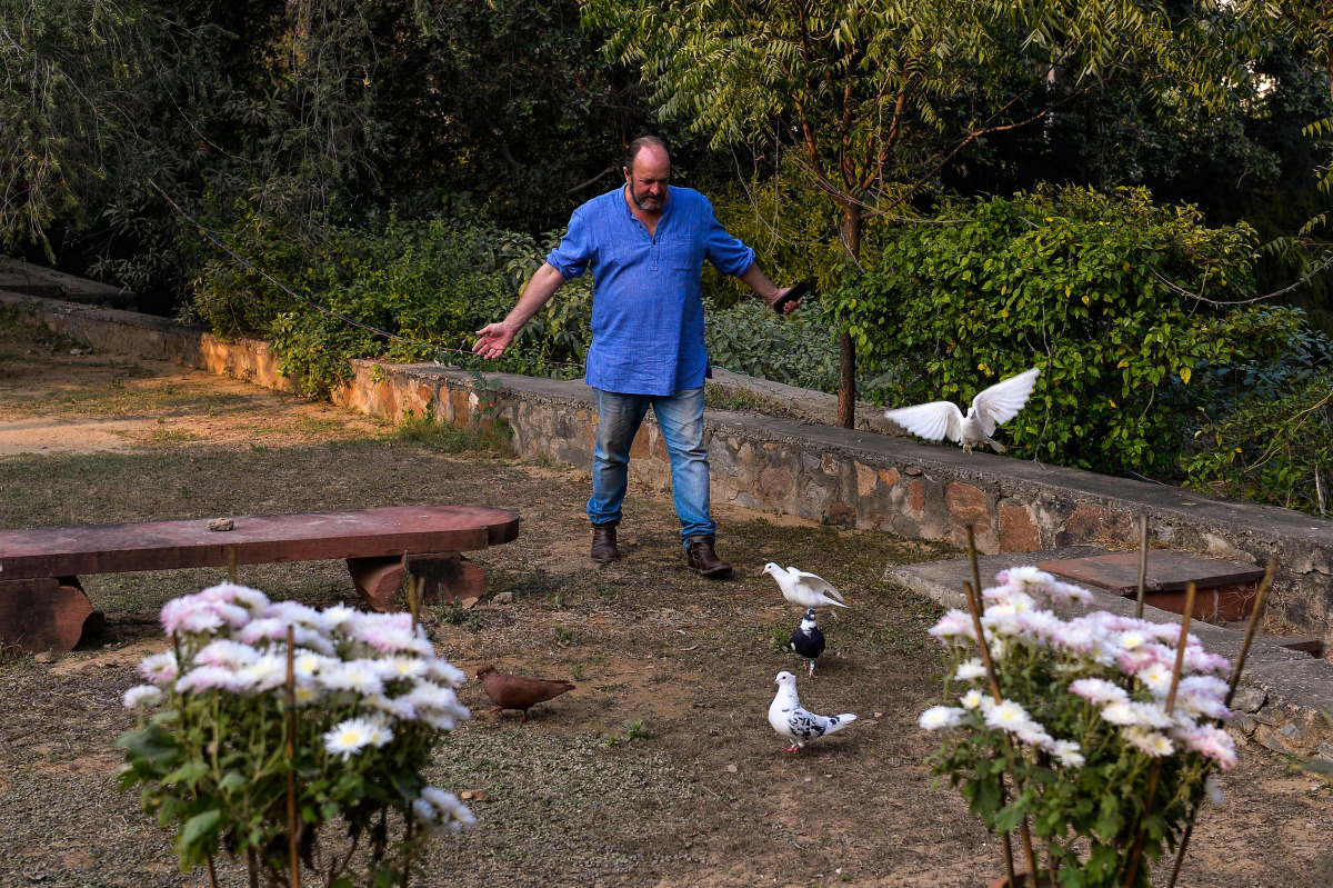 Scottish historian and writer William Dalrymple walks amongst his pigeons at his farm house in New Delhi. Many precious stones have a blood-soaked history, but a new book reveals the world's most famous diamond the Kohinoor surpasses them all, with a lita