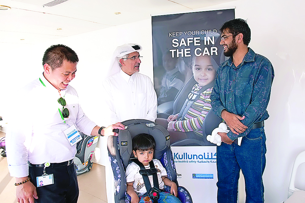 Officials demonstrating the use of child seats in cars.