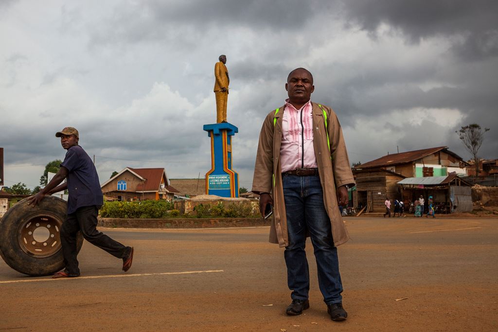 Sauveur Mulwana poses in front of one of the monuments that he created in Butembo on November 11, 2016. AFP / Eduardo Soteras 