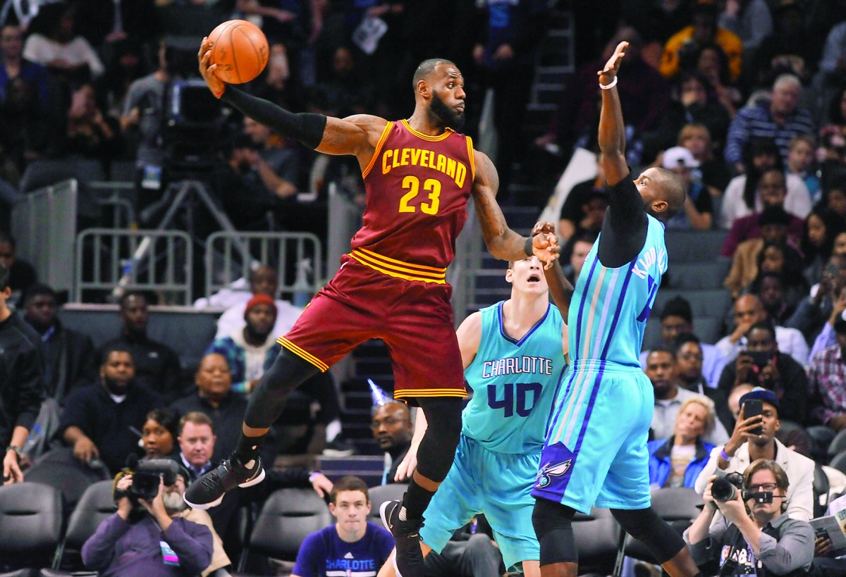 Cleveland Cavaliers' forward LeBron James passes the ball as he is defended by Charlotte Hornets' forward Michael Kidd-Gilchrist and forward centre Cody Zeller during their NBA game at the Spectrum Center on Saturday. Cavaliers won 121-109.