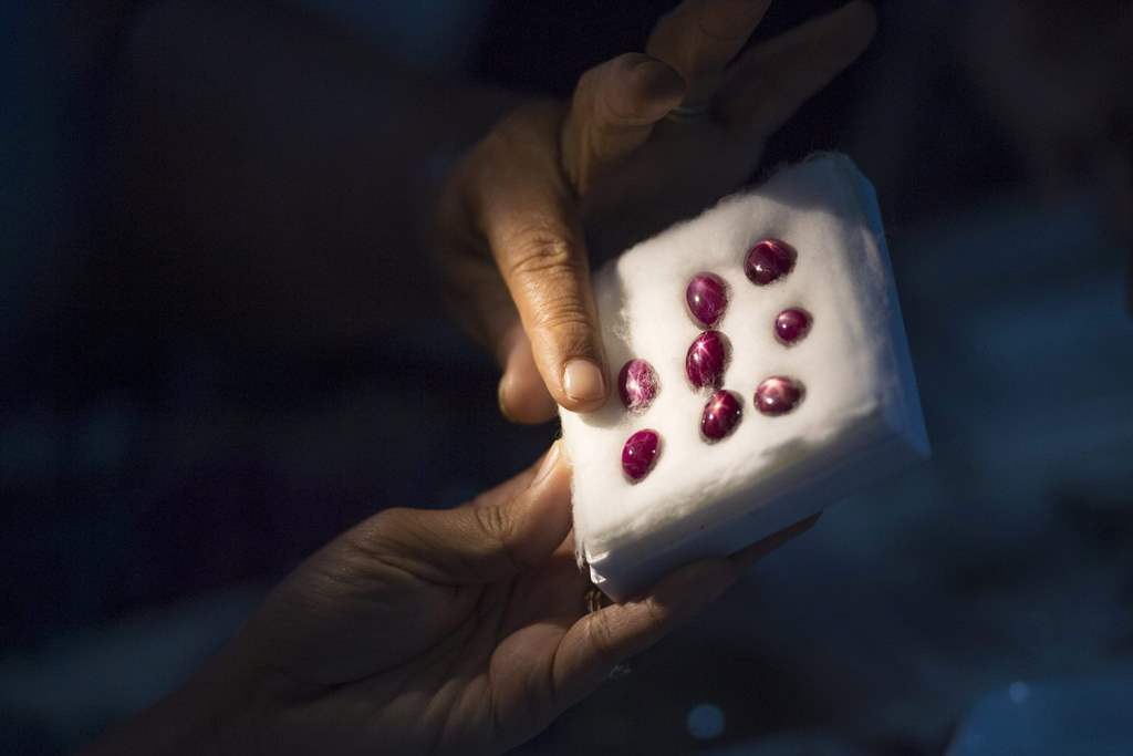 This photo taken on November 22, 2016 shows a buyer looking at rubies in a jade market in Mandalay. AFP / Ye Aung Thu