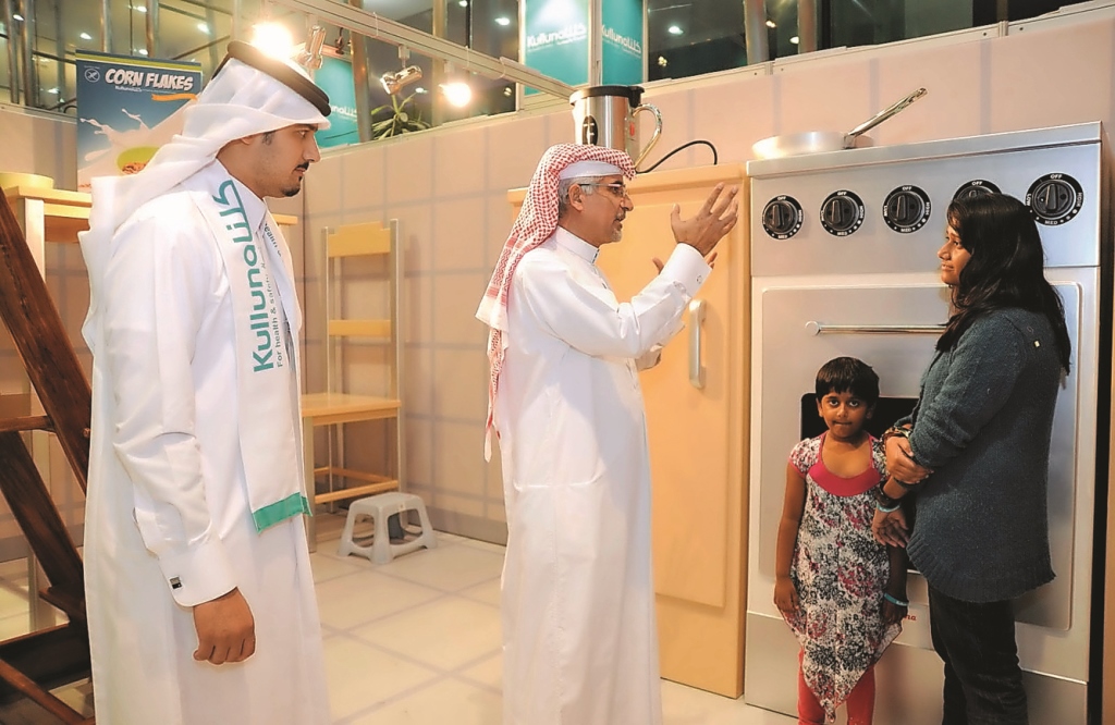 Dr Khalid Abdulnoor Saifeldeen talks to a visitor inside a simulator of a giant kitchen during a Kulluna safety roadshow.