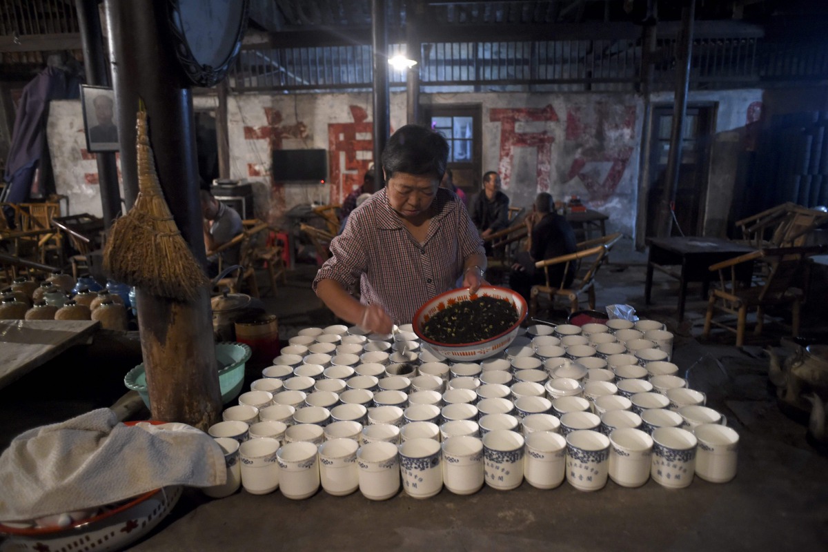 An elderly woman preparing tea for customers at a hundred years old teahouse in the early morning in Chengdu southwest China's Sichuan province on September 11, 2016.  The 50-seat teahouse in Chengdu capital of the southwestern province of Sichuan and the