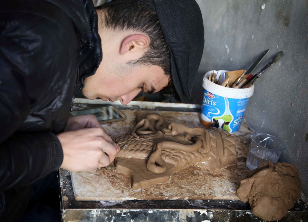 Ninos Thabet, an 18-year-old Christian who studied art at Mosul University, creates miniature replicas of statues destroyed by militants when they overran the 3,000-year-old Assyrian city of Nimrud 2-1/2 years ago, in Erbil, Iraq, January 13, 2017. Pictur