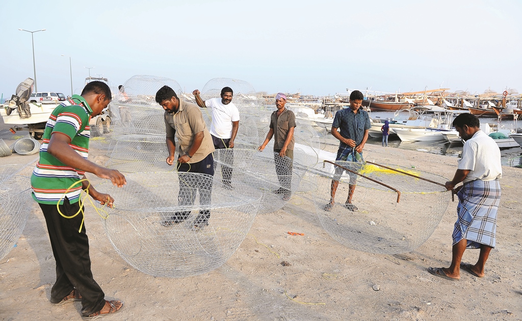 File photo of fishermen fixing ‘Karkur’, a round metal fishing net, at the Al Wakrah fishing port. 