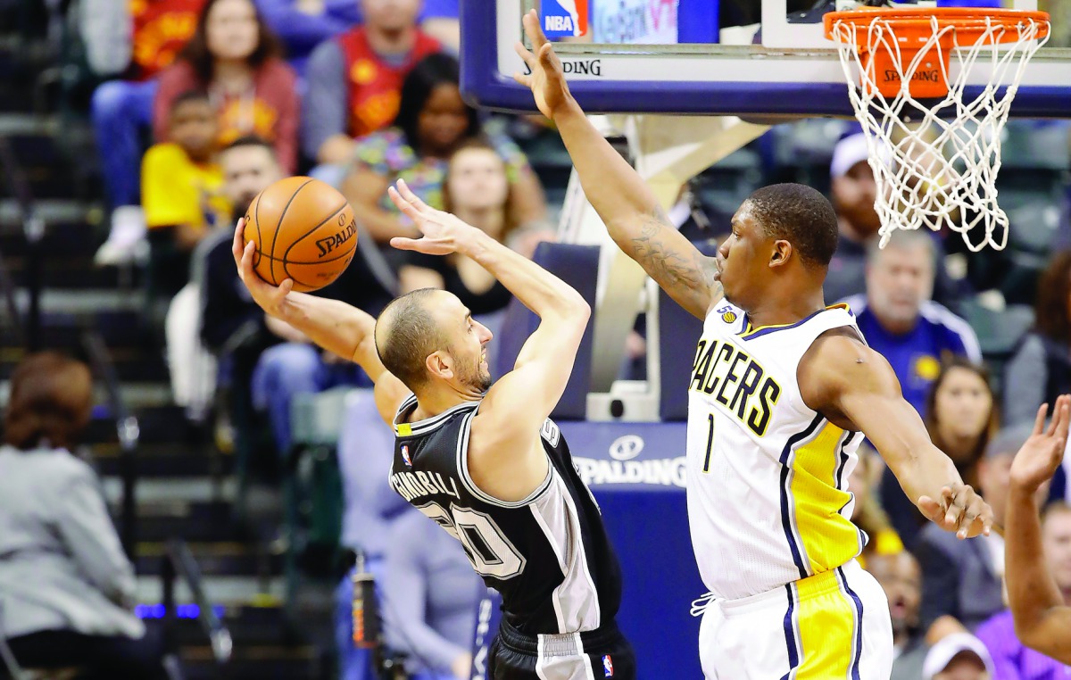 Manu Ginobili (left) of the San Antonio Spurs shoots the ball against the Indiana Pacers during their NBA game played at Bankers Life Fieldhouse on Monday in Indianapolis, Indiana. Spurs clinched their 20th straight winning season with a 110-106 win.