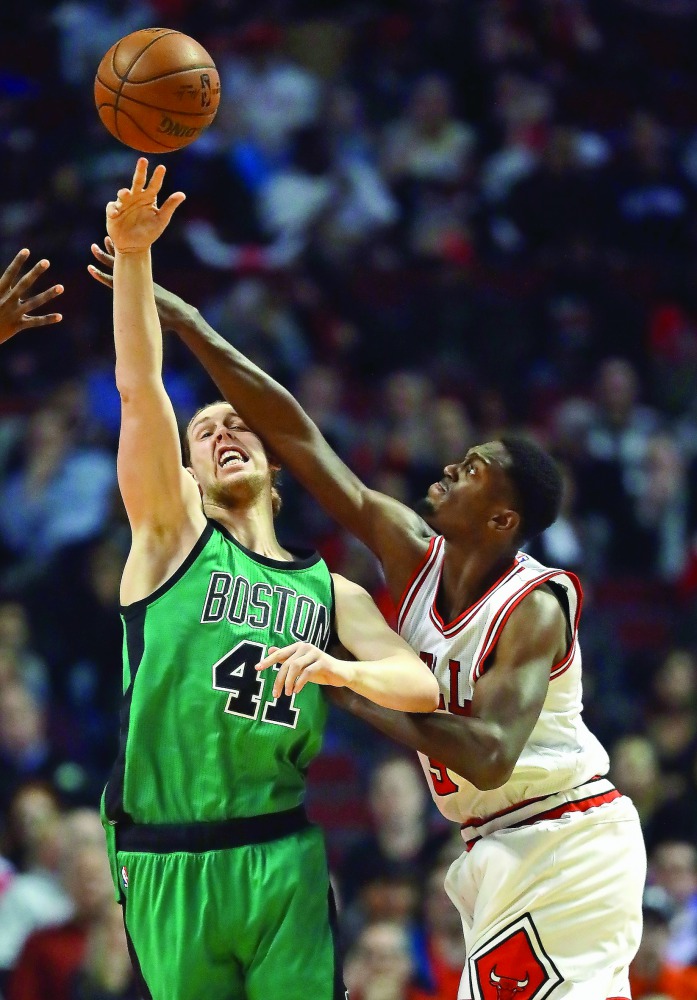 Kelly Olynyk (41) of the Boston Celtics gets off a pass under presure from Bobby Portis (5) of the Chicago Bulls at the United Center in Chicago, Illinois on Thursday.