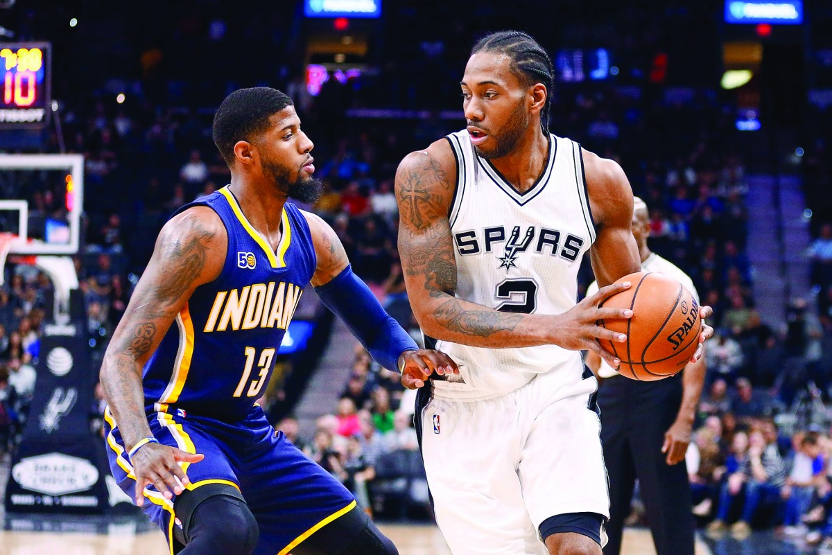 San Antonio Spurs' forward Kawhi Leonard (right) is defended by Indiana Pacers' forward Paul George during the first half of their NBA game in San Antonio on Wednesday. 