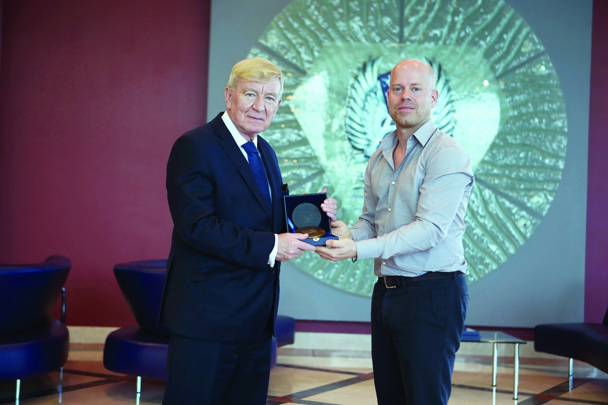 An Aspire Academy official presents a memento to a representative of the Football Association of Wales delegation which is on a visit to Doha.