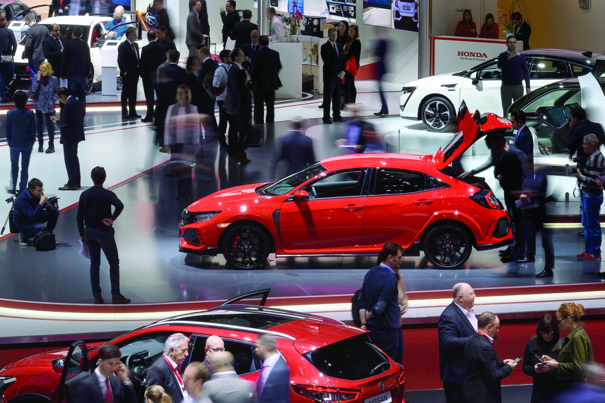 People check cars on the second press day of the Geneva International Motor Show, Europe's biggest annual car show, in Geneva, yesterday.  