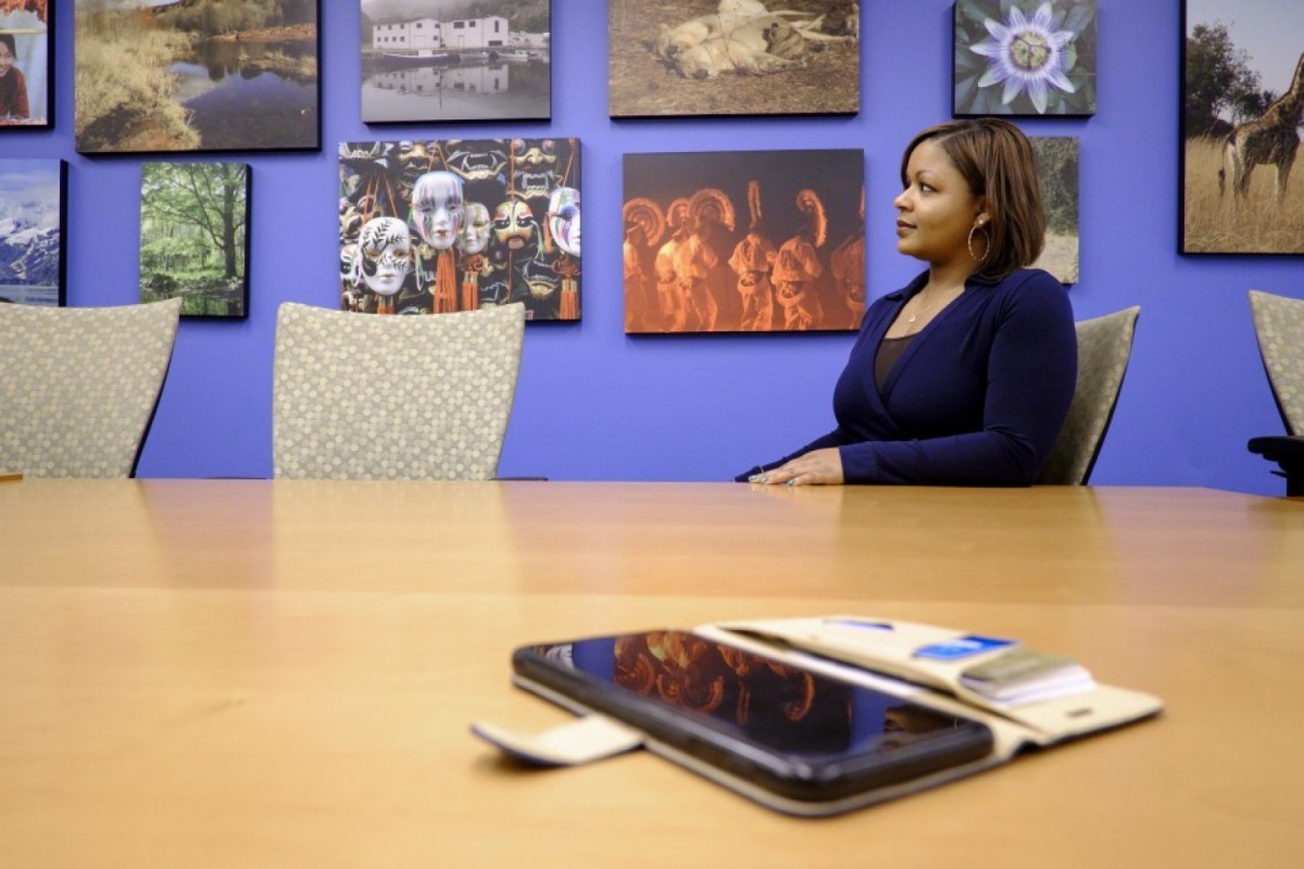 Tiffani Alexander, editor in chief of the ACC Docket, in the conference room adorned with travel photos. Alexander is planning a month long sabbatical to visit Greece and work on her novel. (Photo by Pete Marovich For The Washington Post)