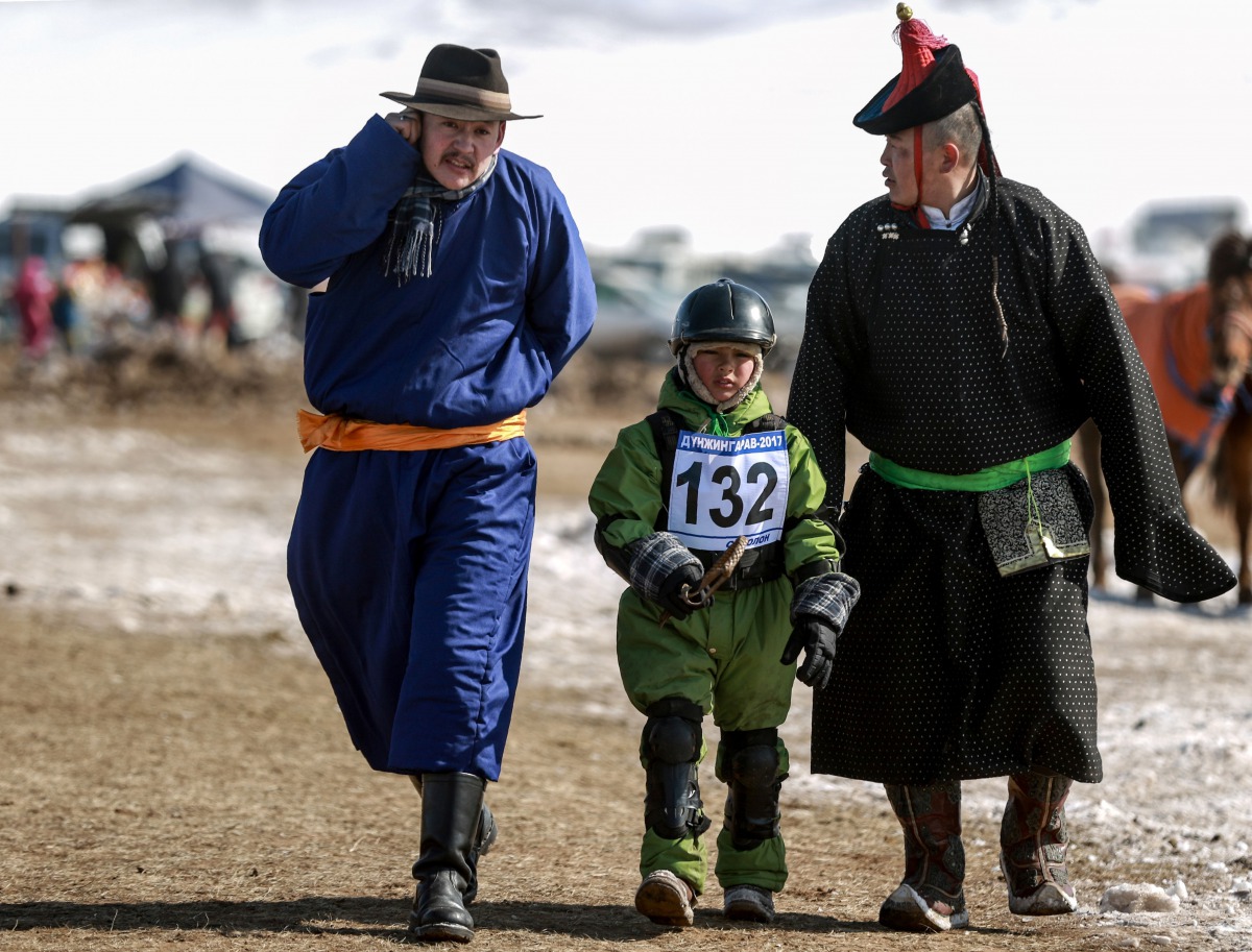 This picture taken on March 5, 2017 shows a Mongolian child jockey (C) preparing to compete in the 