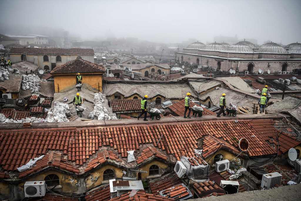 (FILES) This file photo taken on March 1, 2017 shows workers pushing wheelbarrows on the top of Istanbul's iconic marketplace, the Grand Bazaar, during its renovation in Istanbul. AFP / OZAN KOSE
