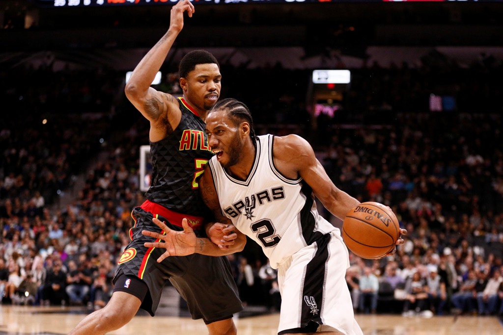 San Antonio Spurs small forward Kawhi Leonard (2) dribbles the ball as Atlanta Hawks small forward Kent Bazemore (left) defends during the second half at AT&T Center. Soobum Im