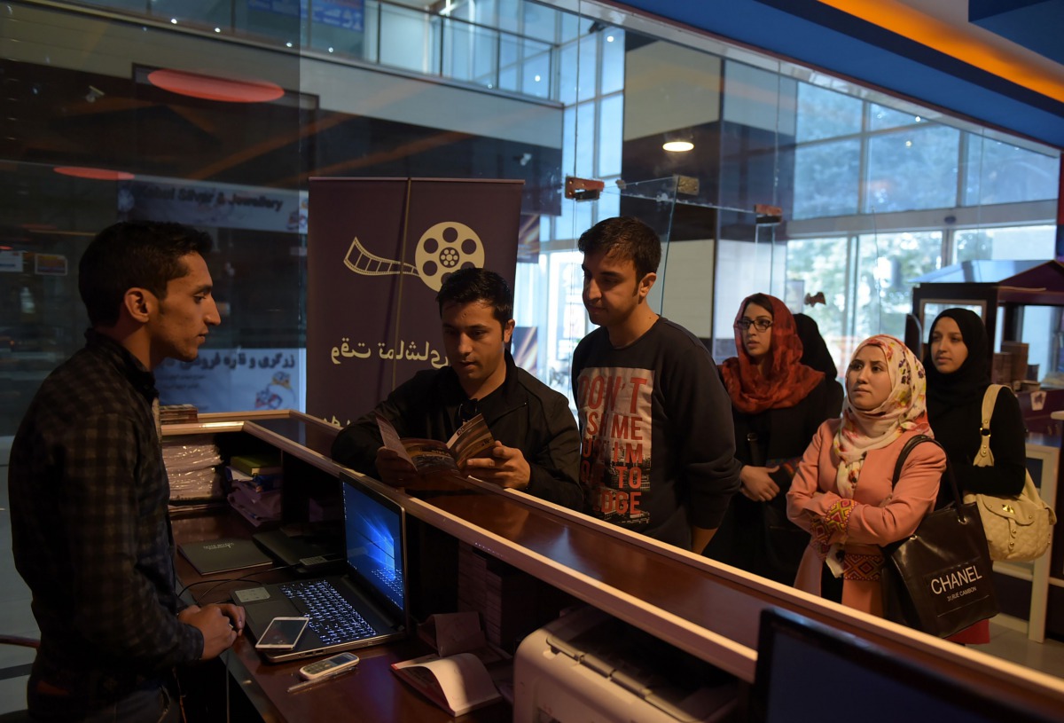 An Afghan family queue to buy tickets at the Galaxy Family Cinema in Kabul In this photograph taken on November 4 ,2016.  AFP / Shah Marai