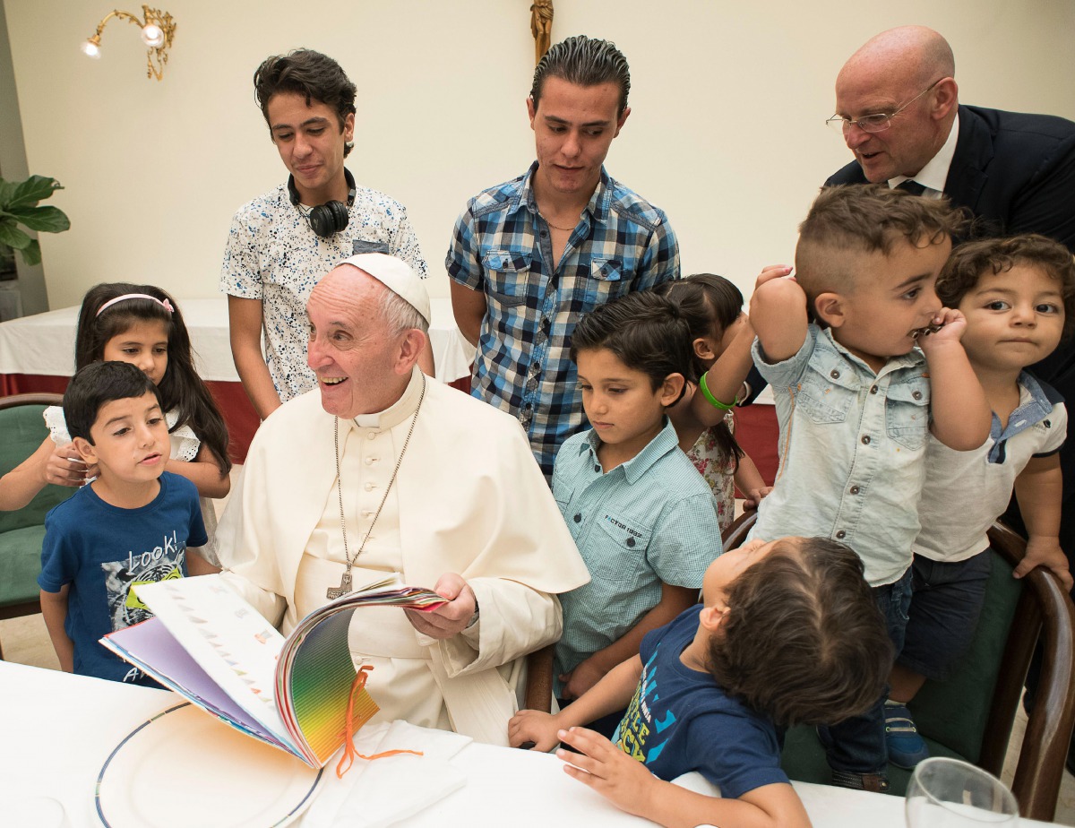 FILE PHOTO: Pope Francis reading a book to Syrian refugee children at the Vatican ( Casa Santa Marta via AFP) 