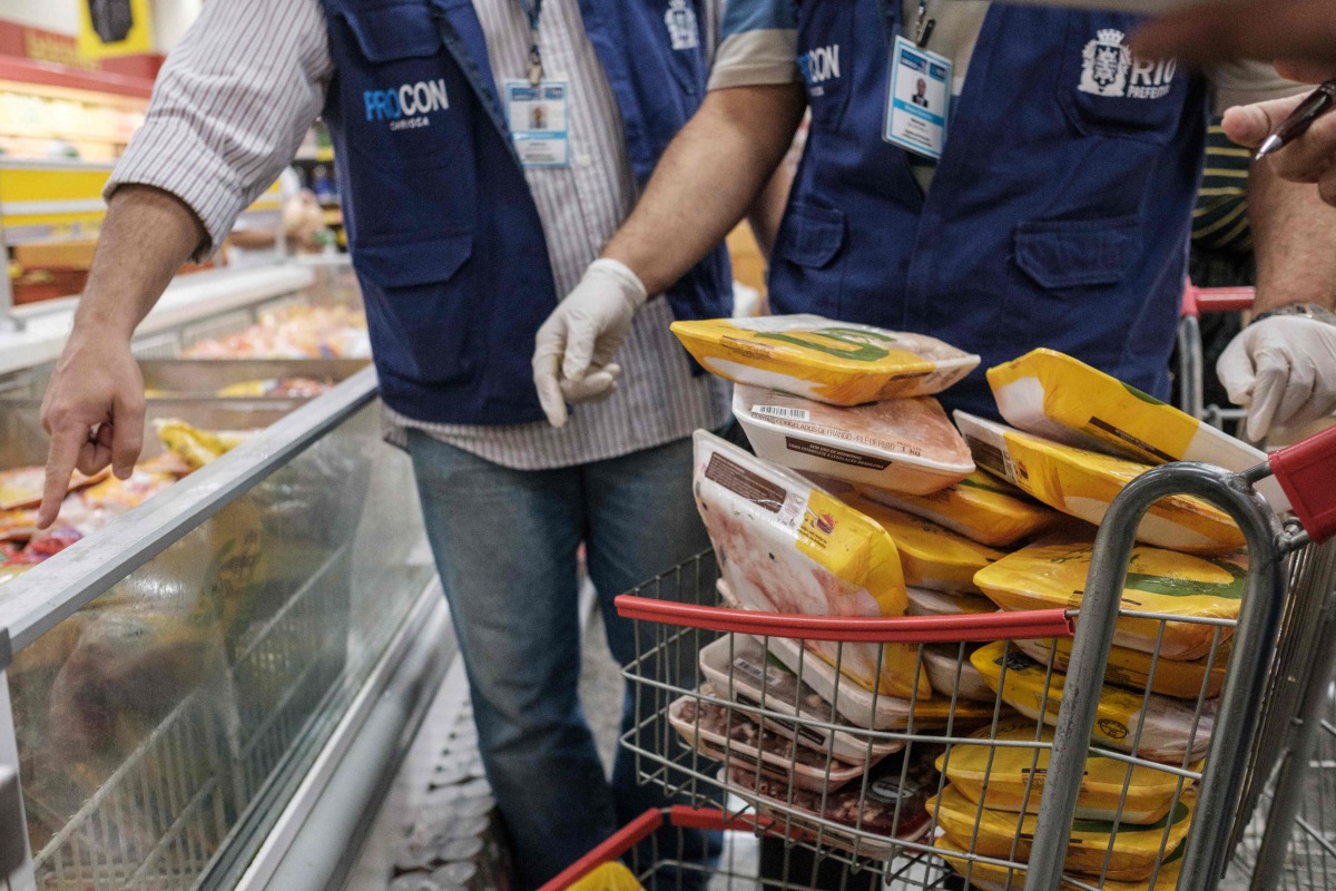 The staff of Rio de Janeiro state's consumer protection agency, PROCON, inspect and remove chicken products that are not frozen from a freezer at a supermarket in Rio de Janeiro, Brazil, on March 24, 2017. Brazil, the world's biggest beef and poultry expo