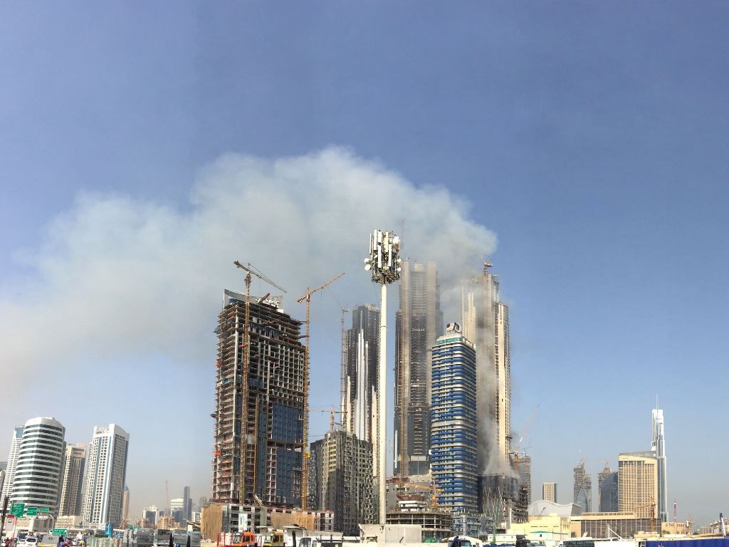 Smoke billows near the Dubai Mall and Burj Khalifa, the world's tallest building, after a fire hit the construction site in Dubai on April 2, 2017. A blaze erupted in a residential complex under construction near Dubai's biggest shopping mall and a hotel 