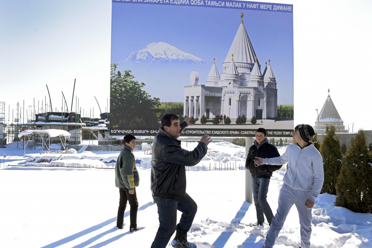 Misha Davrshyan, an Armenian man from the Yazidi community, points to a placard at the construction site of a new Yazidi edifice, called Quba Mere Diwane, in the village of Aknalich, 35 kilometres from the Armenian capital Yerevan, on February 2, 2017. A 