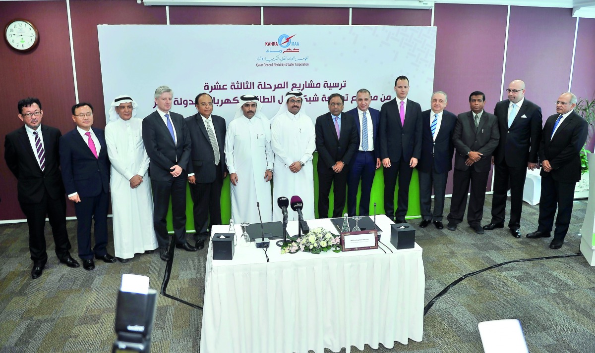 Minister of Energy and Industry H E Dr Mohammed bin Saleh Al Sada and Kahramaa President Eng Issa bin Hilal Al Kuwari, with representatives of the companies after signing the contracts, at Kahramaa Tower, yesterday.  Pic: Baher Amin /The Peninsula
