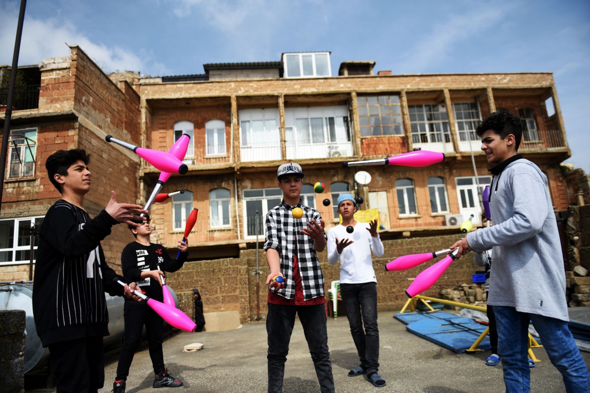 Syrian boys juggle on a roof of a building on March 19, 2017, in Mardin. Some children are perched on stilts, others are spinning plates or happily performing aerial dances. But this is not the big top circus in a major city but a house in southeastern Tu