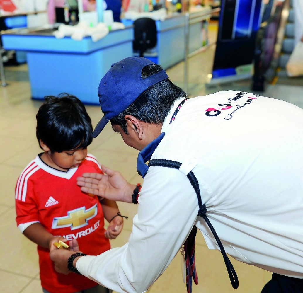 A security guard at Lulu Hypermarket consoling a child. Pic: Salim Matramkot / The Peninsula