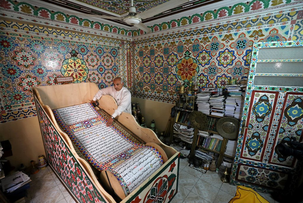 Saad Mohammed rolls down what he says is the largest handwritten version of Koran in the world measuring around 700 meters long, the town of Belqina, north of Cairo, Egypt, April 26, 2017. Picture taken April 26, 2017. REUTERS/Mohamed Abd El Ghany