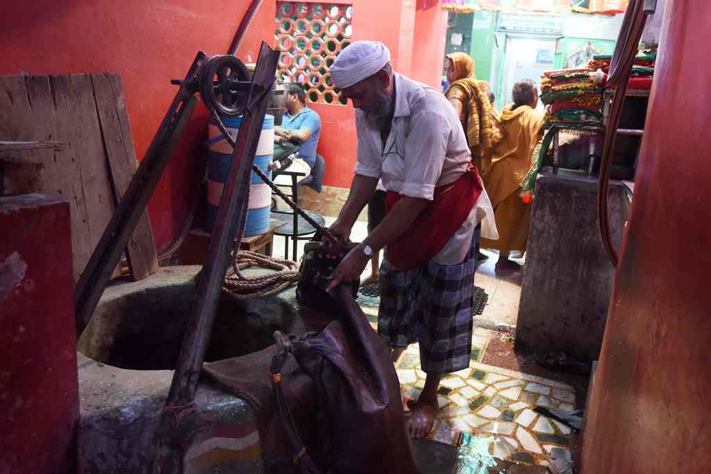 In this photograph taken on March 31, 2017, Indian water carrier Shakeel Ahmad fills up a goat hide canteen from a well in New Delhi. AFP / Dominique FAGET 