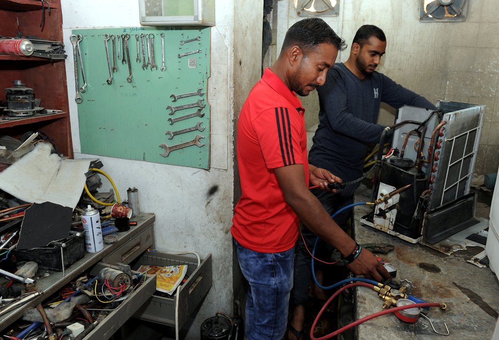 Mechanics of at a AC repair shop working at their workshop in the Old Airport, Doha.  Salim Matramkot © The Peninsula