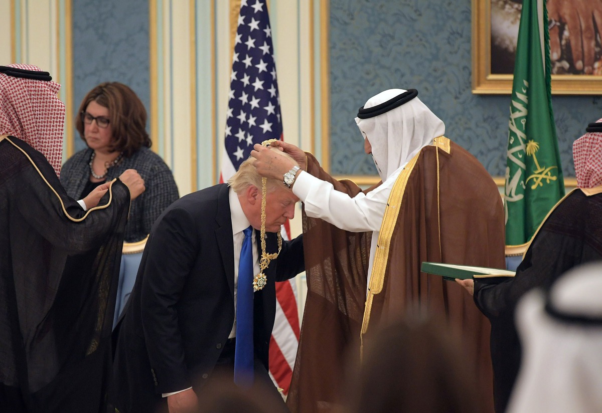 US President Donald Trump (C) receives the Order of Abdulaziz al-Saud medal from Saudi Arabia's King Salman bin Abdulaziz al-Saud (R) at the Saudi Royal Court in Riyadh on May 20, 2017.  AFP / MANDEL NGAN
