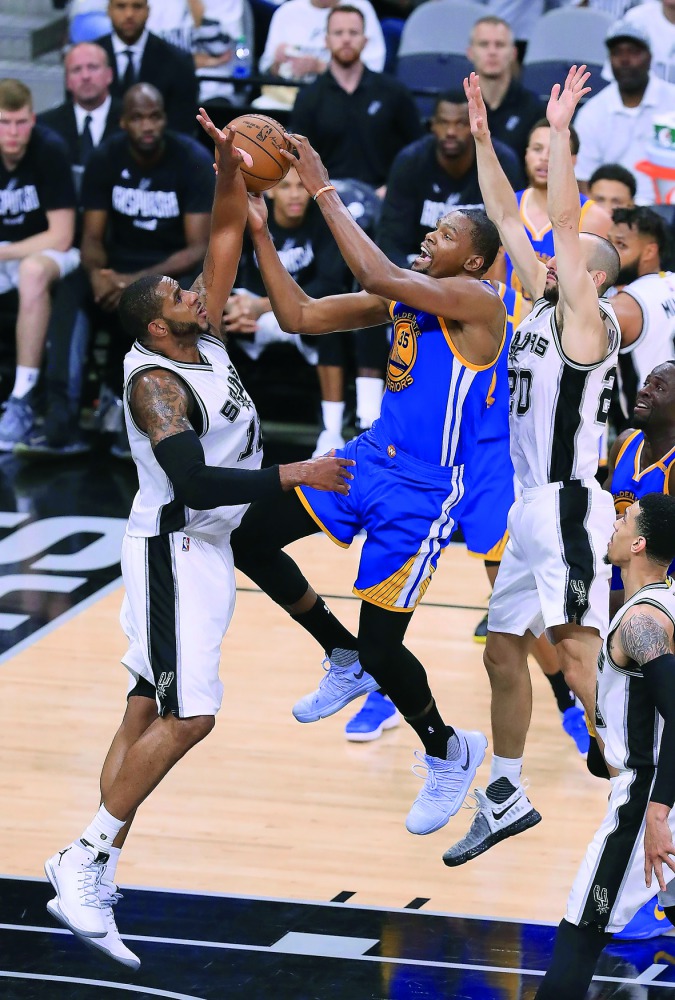 Kevin Durant (centre) of the Golden State Warriors drives to the basket against the San Antonio Spurs in the second half during Game Three of their 2017 NBA Western Conference Finals at AT&T Center on Saturday in San Antonio, Texas.