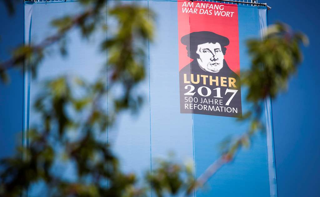 A portrait of Martin Luther is seen on the side of a giant book displaying all the pages of the bible on its back side in the Lutherstadt Wittenberg, eastern Germany, on May 18, 2017. AFP / Odd ANDERSEN