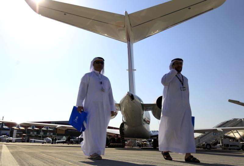 Visitors walk past aircraft on display during the Middle East Business Aviation show at Al Maktoum International Airport in Dubai World Central, December 11, 2012. REUTERS/Jumana El Heloueh