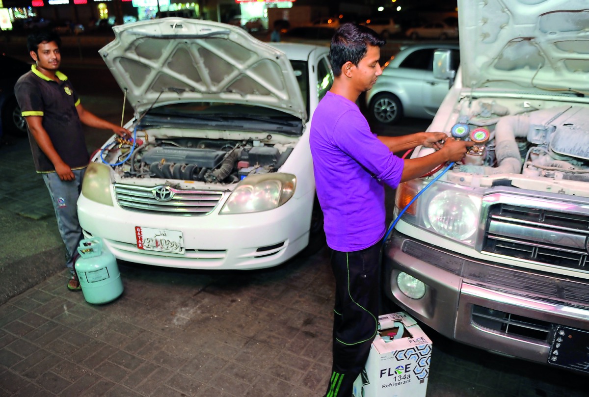 Car AC mechanics at work in Doha.  Pic: Abdul Basit/ The Peninsula