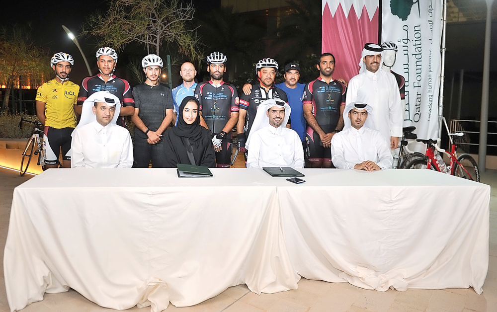 Machaille Al Naimi (centre), President of Community Development at Qatar Foundation and Dr Abdulaziz Al Kuwari, Chairman of Qatar Cyclists group, with officials and riders during the MoU signing at Awsaj Academy Recreation Center yesterday. Pic: Baher Ami