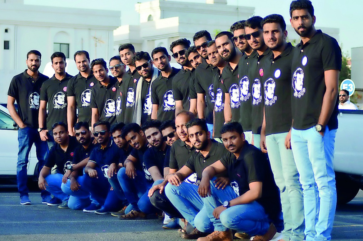 Expatriates wearing T-shirts bearing portrait of the Emir.