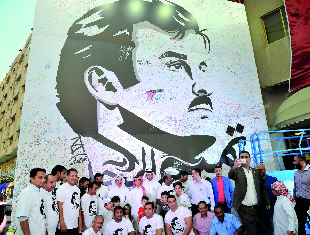 Ibrahim A Al Muftah, Managing Director of Al Muftah Group of Companies, and other officials in front of the image of Emir H H Sheikh Tamim bin Hamad Al Thani, in Al Sadd yesterday. 
Pic: Kammutty VP / The Peninsula 