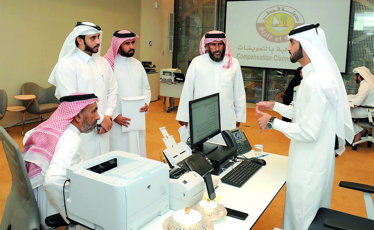 Officials receiving complaints from people at the Compensation Claims Committee headquarters at Doha Exhibition and Convention Center, yesterday. 