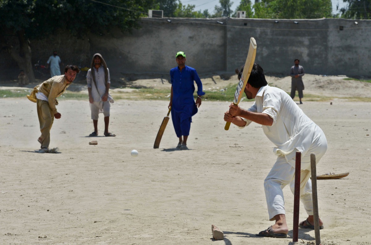 In this photograph taken on July 6, 2017, Afghan refugees play a cricket match at the Khurasan refugee camp in the suburbs of Peshawar. 