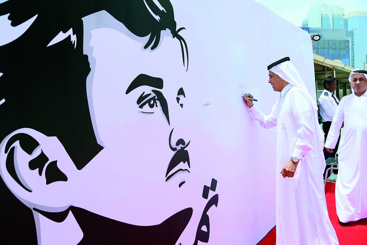 Sheikh Khalid bin Mohammed bin Ali Al Thani, Chairman of the Board of Directors of QIC, signing the mural in the presence of Khalifa Abdullah Turki Al Subaey, Group President & CEO of QIC Group. 