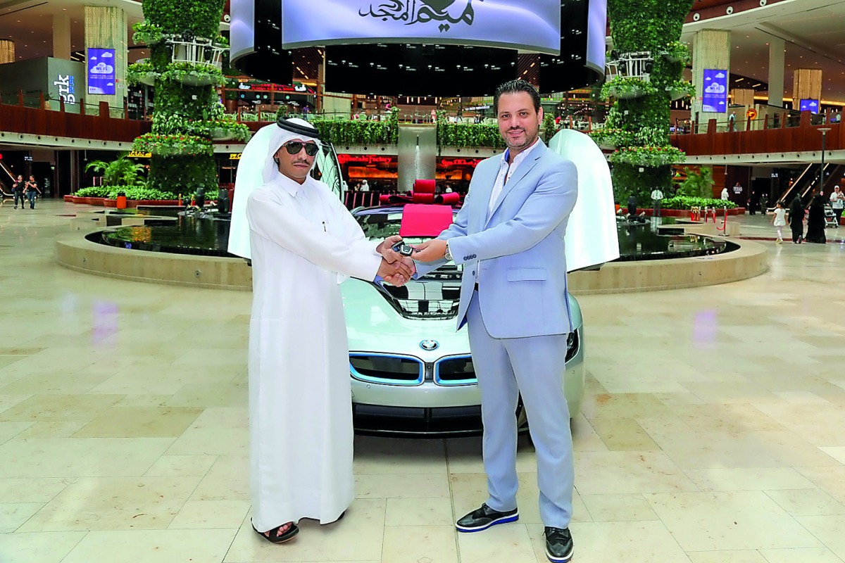 Hassan Ahmad Al Marri, the winner of Mall of Qatar’s (MOQ) ‘Shop and Win’, receiving the keys of BMW i8 from Rony Mourani, General Manager of MOQ. 