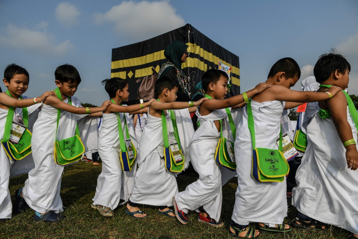 Ihram-clad Malaysian Muslim boys from the Little Caliphs kindergarten circumambulate a mockup of the Kaaba, Islam's most sacred structure located in the holy city of Makkah, during an educational simulation of the Haj pilgrimage in Shah Alam, outside Kual