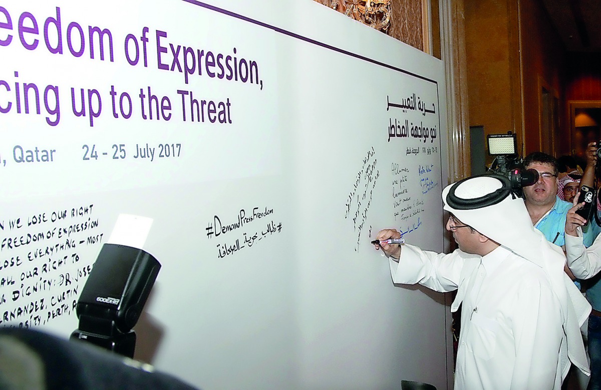 Dr Ali bin Sumaikh Al Marri, President of the NHRC Qatar, writing his commends during the International Conference on Freedom of Expression Facing Up to the Threat, yesterday.