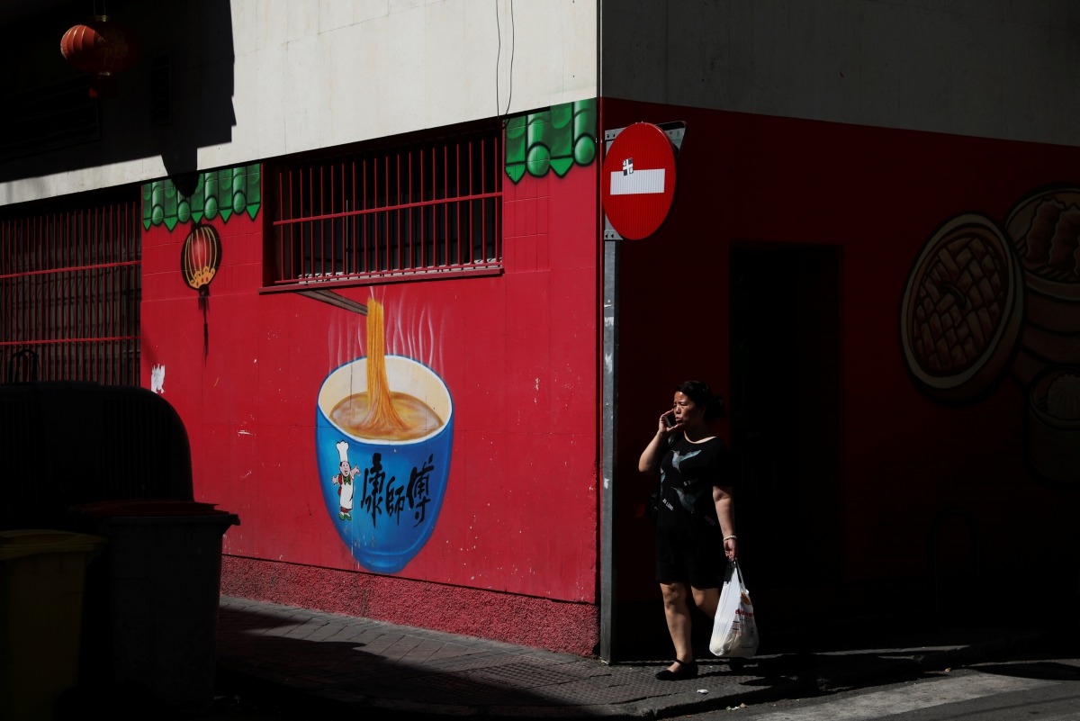 A woman walks past a Chinese food store at Usera district in Madrid, Spain, July 24, 2017. Reuters /Susana Vera