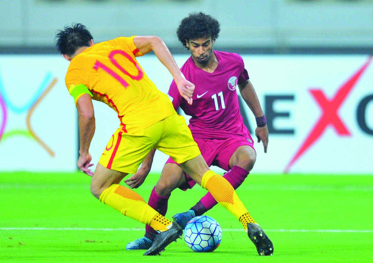 Akram Afif of Qatar attempts to break through Chinese defence during their FIFA World Cup 2018 qualifier which took place at Khalifa International Stadium  in Doha yesterday. China won 2-1.
Picture: Baher Amin/The Peninsula