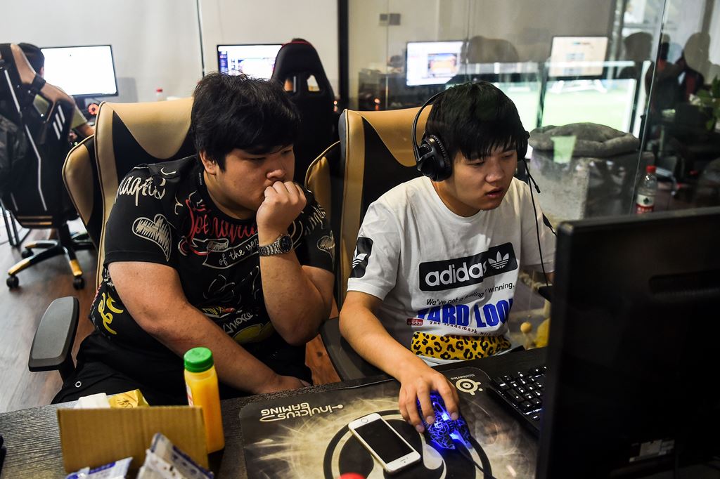 In this photograph taken on September 20, 2017, eSports gamers play League of Legends during training for the League of Legends World Championship at a boot camp in Shanghai. AFP / CHANDAN KHANNA 