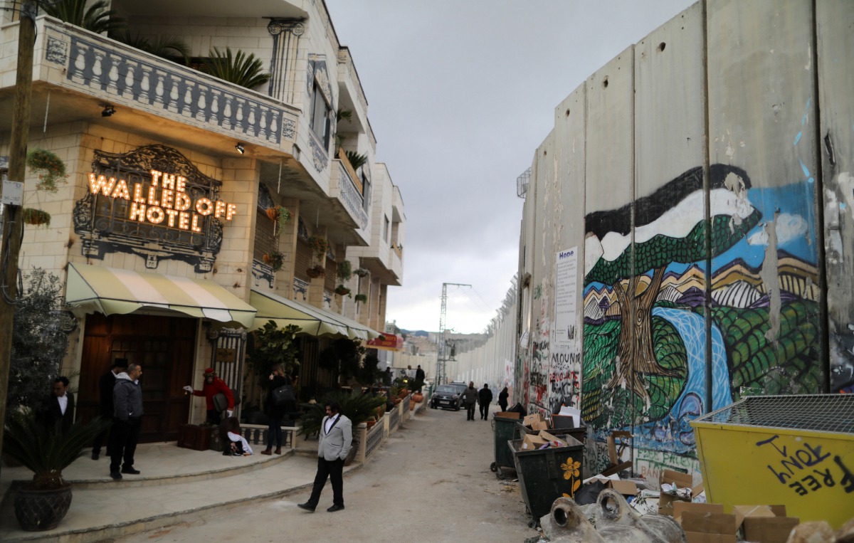 People stand outside the Walled Off hotel, which was opened by street artist Banksy in the West Bank city of Bethlehem, March 3, 2017 (REUTERS / Ammar Awad) 