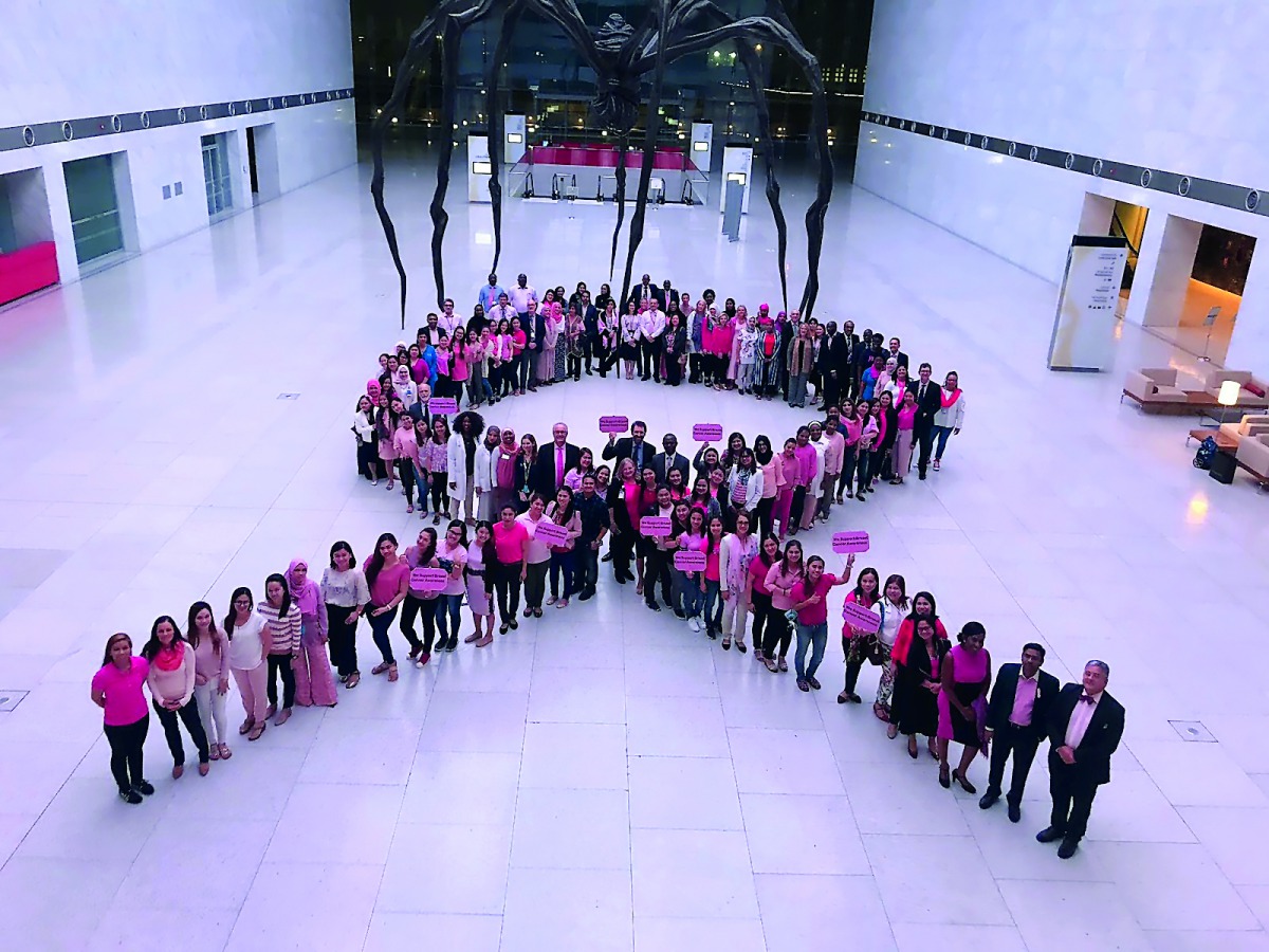 Participants pose for an awareness campaign supporting breast cancer month.