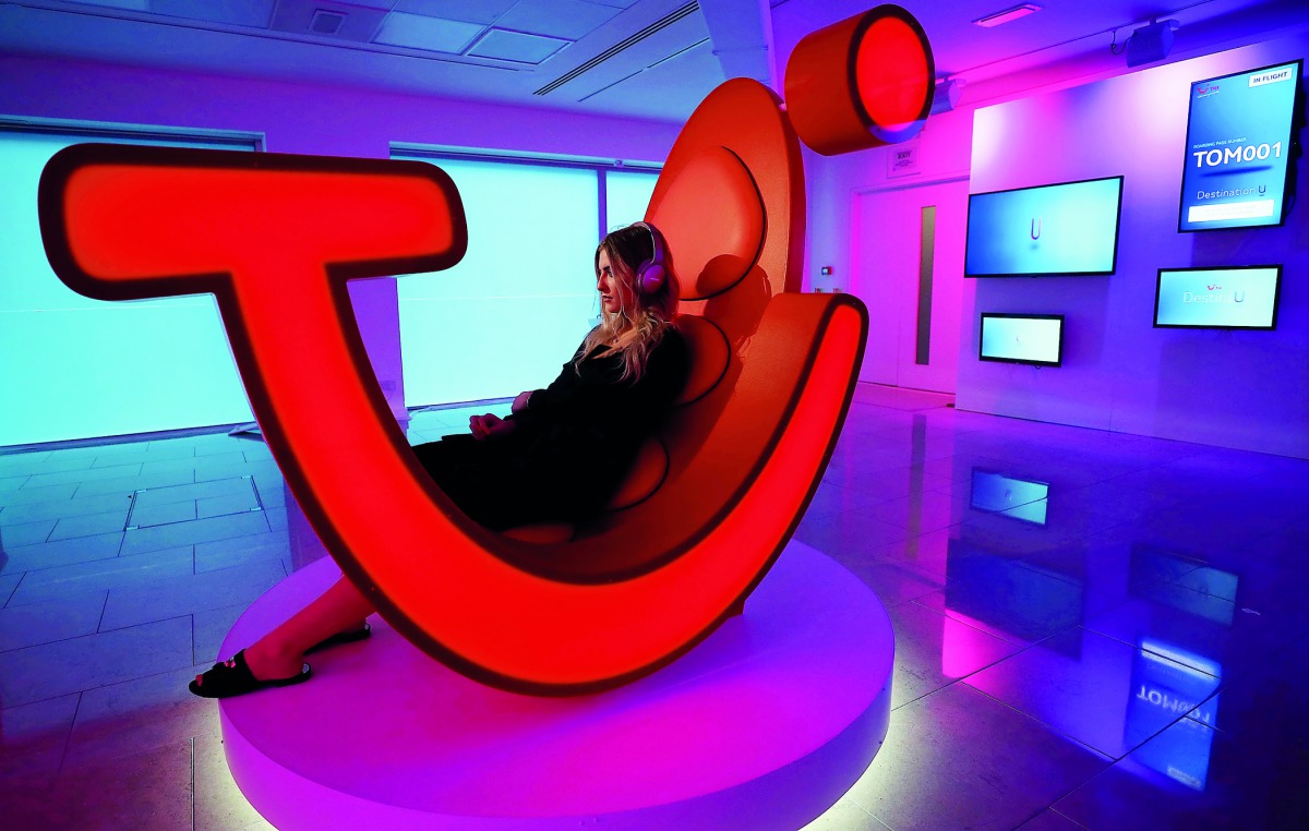 A woman demonstrates a prototype of a new TUI holiday-selection service as the company announced the rebranding of its UK operation, in London, Britain, October 17, 2017. Picture taken on October 17, 2017. Reuters/Hannah McKay