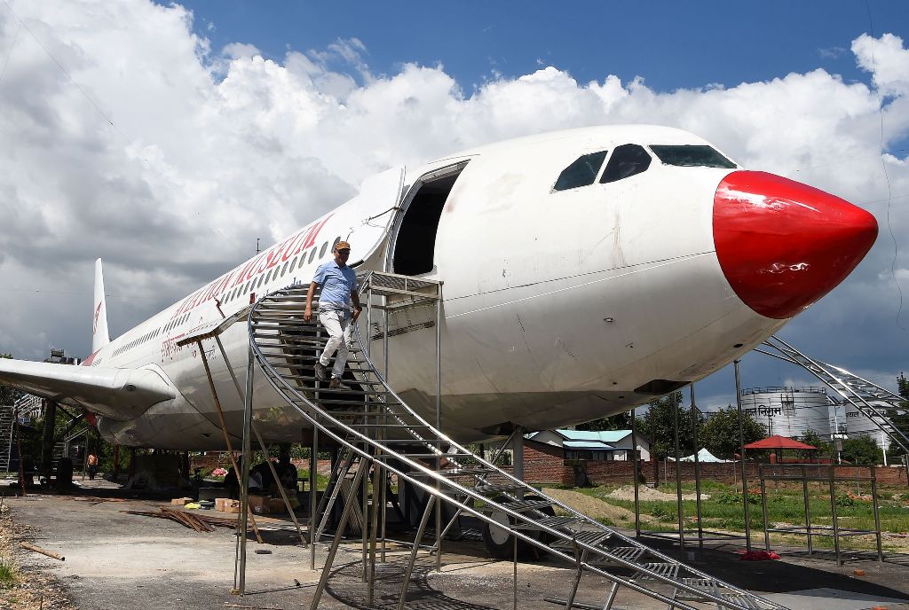 In this photograph taken on July 18, 2017 Nepali pilot Bed Upreti walks from an airplane that has been converted into an aviation museum in Kathmandu./ AFP / PRAKASH MATHEMA